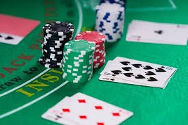 Close-up tangan dealer blackjack di studio langsung colok sgp dengan kartu dan chip taruhan terlihat